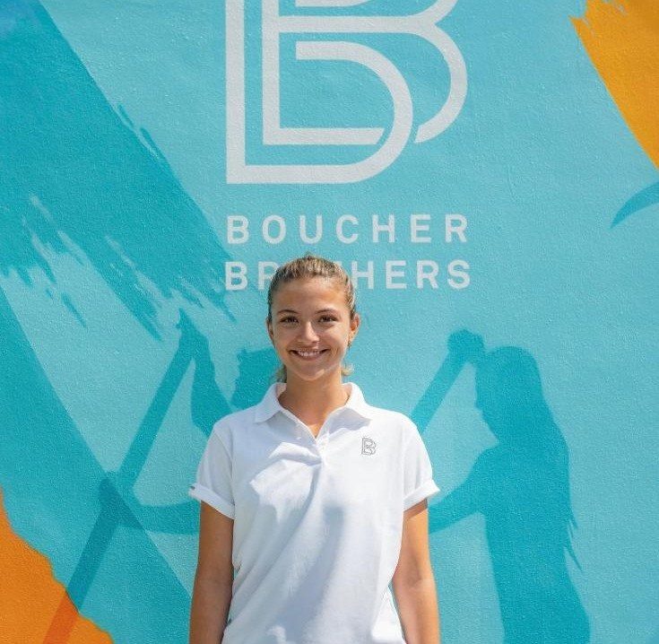 身穿白色制服的 Boucher Brothers 员工站在公司壁画前